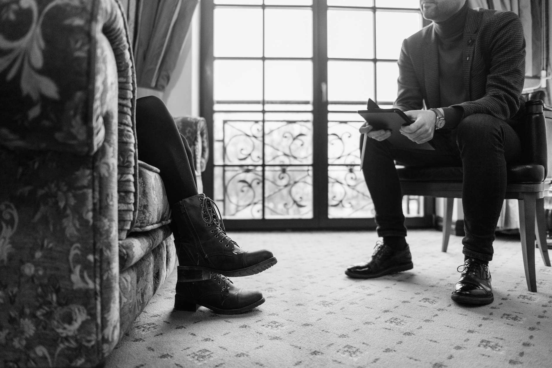 Czarno-biała scena rozmowy pacjenta z terapeutą w gabinecie