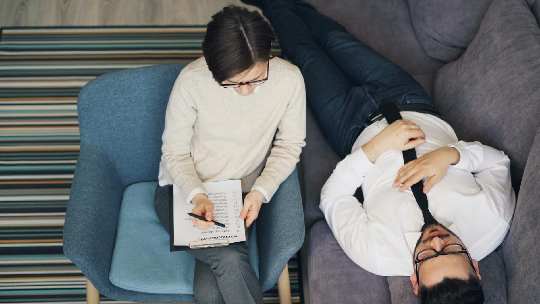 Pacjent na kanapie rozmawia z terapeutą o zdrowiu psychicznym